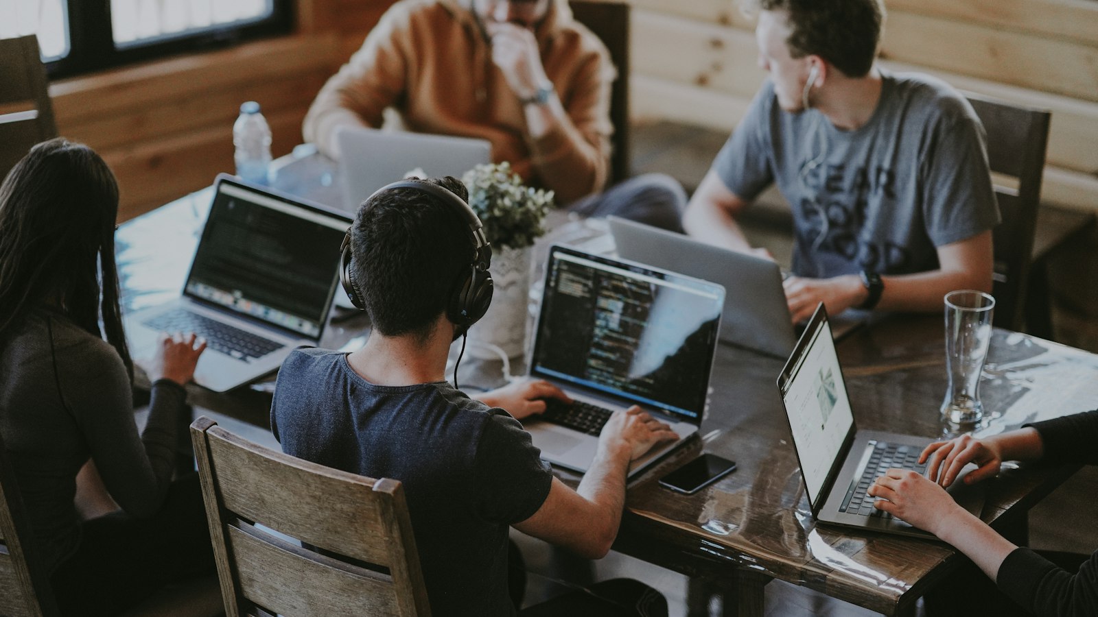 A team of engineers and marketers working together on laptops around a shared table